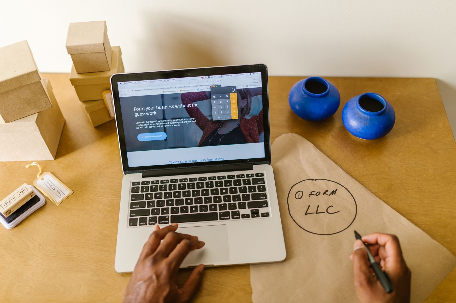 Workspace with laptop, packaging, and handwritten notes, ideal for a small business startup scene.